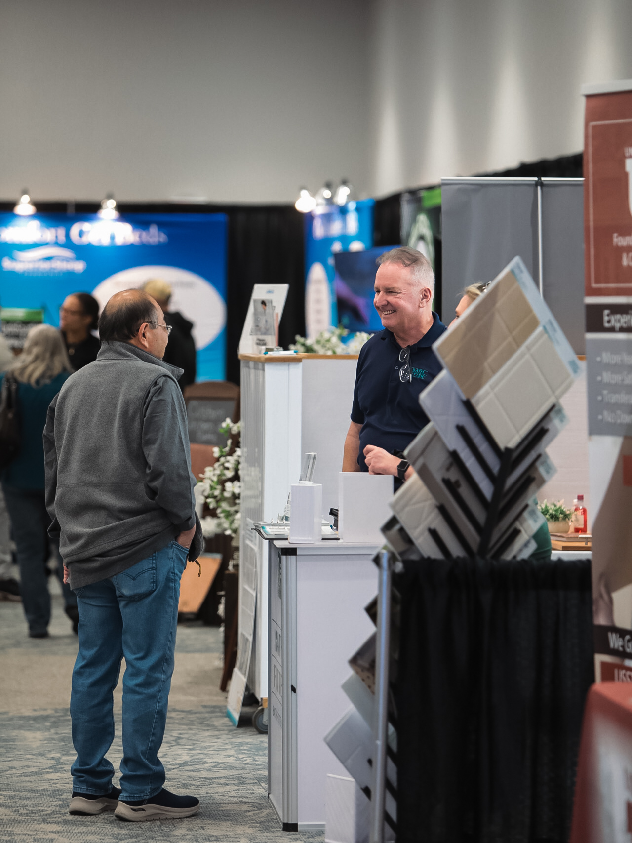 A visitor discussing a product with a home-show professional